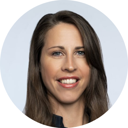 Elisa Puls Rundes Porträtfoto einer lächelnden Frau mit langem braunem Haar vor einem hellblauen Hintergrund.